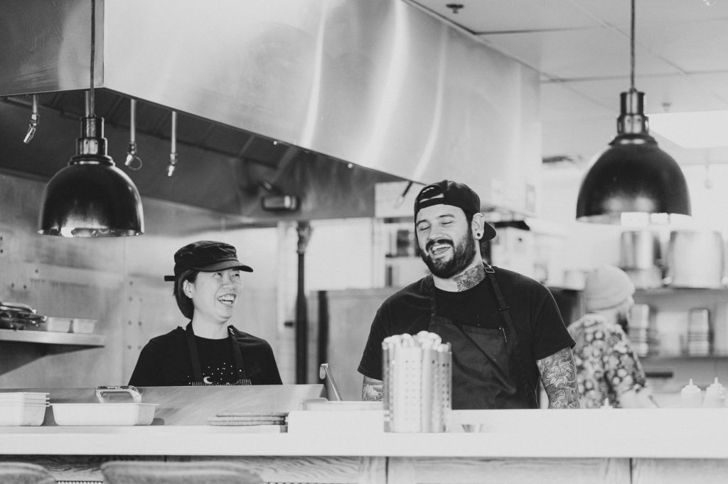 Two persons in the kitchen at Nola having a laugh — Winnipeg Manitoba